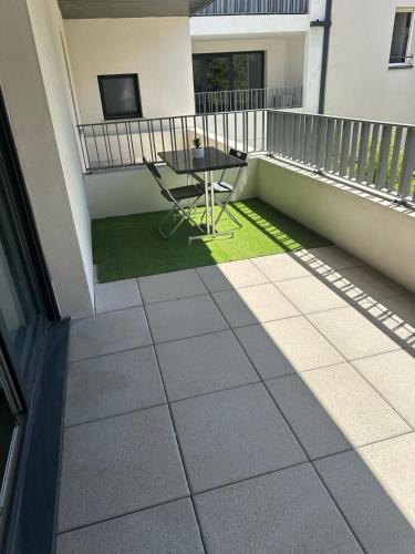 d'une terrasse avec une table sur un balcon. dans l'établissement T2 proche de Montpellier, à Vendargues