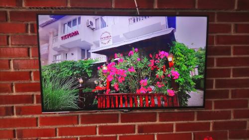 a brick wall with a picture of flowers in a window at Victoria Family Hotel in Balchik