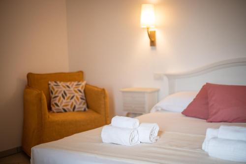 a bedroom with two beds and a chair with towels at Masseria Galleppa by Apulia Hospitality in Monopoli