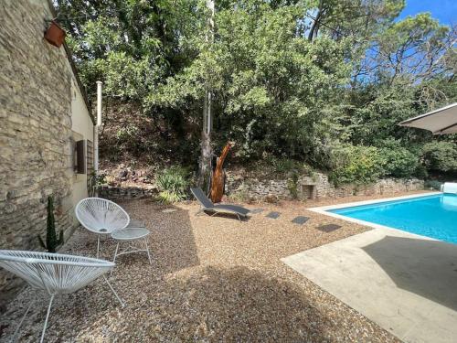 un patio avec des chaises et une piscine dans l'établissement Villa climatisée avec piscine, à Gordes