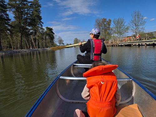 two children are in a boat on the water at Norrqvarn Hotel & Resort by Vänerport in Lyrestad