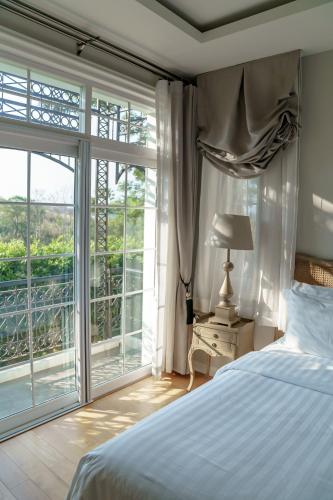 a bedroom with a bed and a large window at CastellStay in Campson