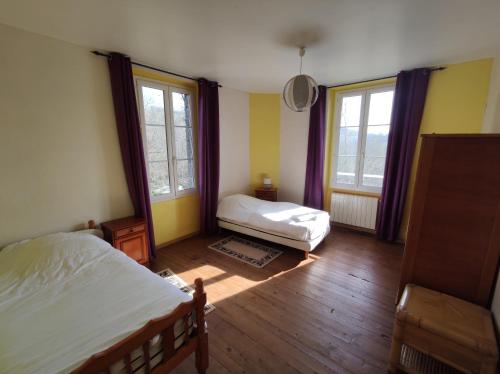 une chambre avec deux lits et deux fenêtres dans l'établissement Le Dojo de Saint Christophe, à Saint-Christophe