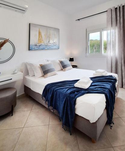 a bedroom with a large bed with a blue blanket at Marisa in Ierapetra
