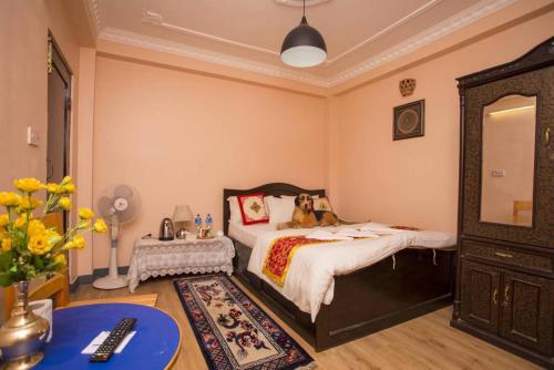 a bedroom with a bed with two dogs sitting on it at Blue Mountain Home Stay in Kathmandu