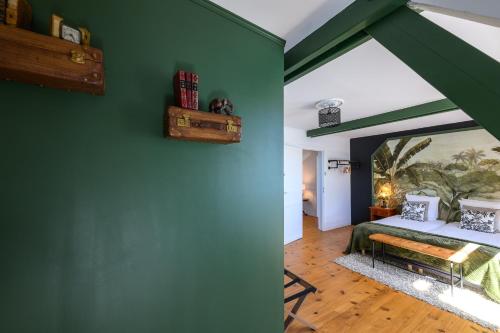 a bedroom with green walls and a bed in a room at Les 13 lavoirs d'antan - chambre globe-trotteur in Saint-Pierre-Église