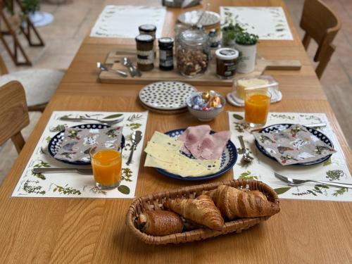 a table with plates of food and a basket of food at Chambre pour 2 personnes, forêt, piscine in Arbonne-la-Foret