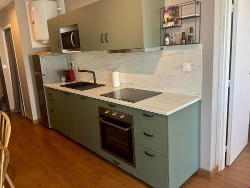 une cuisine avec un évier et un plan de travail dans l'établissement Jolie appartement à Carnon Plage, à Mauguio