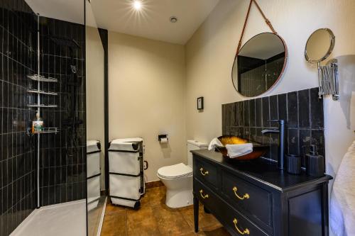 a bathroom with a toilet and a glass shower at Les 13 lavoirs d'antan - chambre globe-trotteur in Saint-Pierre-Église