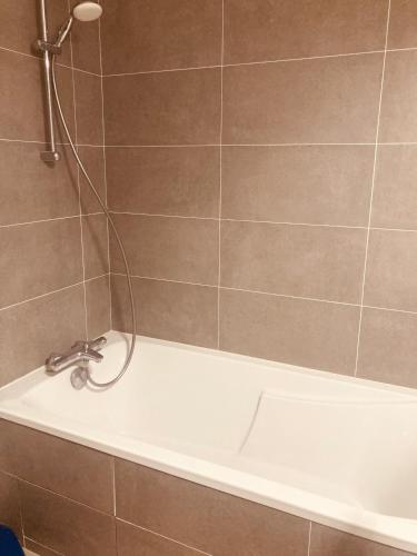 La salle de bains est pourvue d'une baignoire et d'une douche. dans l'établissement Belle chambre avec accès à une terrasse, à Paris