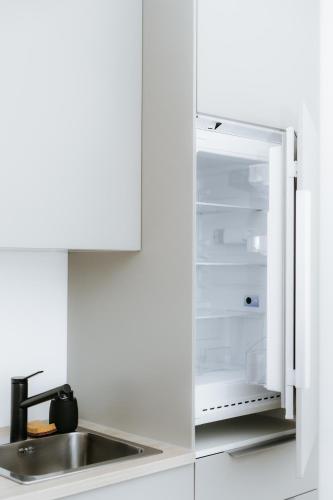 an empty refrigerator with its door open next to a sink at Apartmán Denali in Súľov