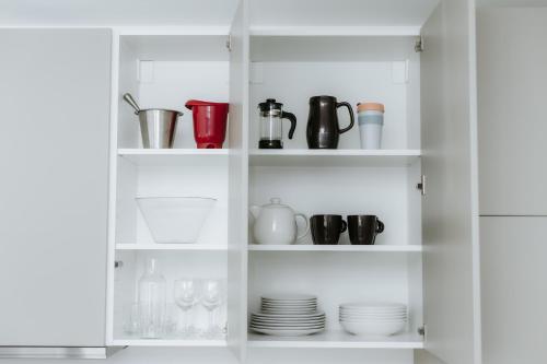 a white cabinet filled with cups and plates at Apartmán Denali in Súľov