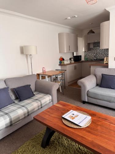 a living room with two couches and a table at Seaforth Cottage -Dog friendly, Historical Fishertown, central location in Nairn