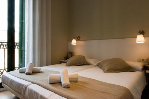 une chambre avec deux lits avec des serviettes dessus dans l'établissement Palau de la Musica Apartments, à Barcelone