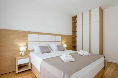 a bedroom with a large bed with two towels on it at Apartments BB in Becici