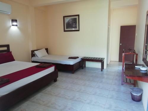 a hotel room with two beds and a table at Dream Day Leisure Homes in Sigiriya