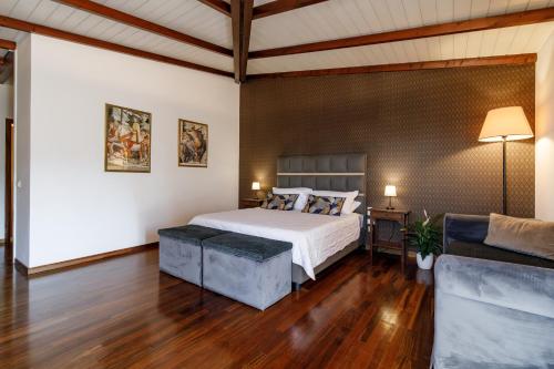 a bedroom with a bed and a couch at Agriturismo Villa Godenano - Pool&Restaurant in Castellina in Chianti