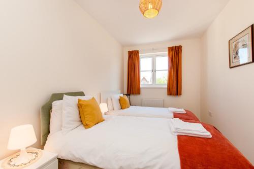 a bedroom with two beds and a window at St Augustines Seaside Retreat in Westgate on Sea