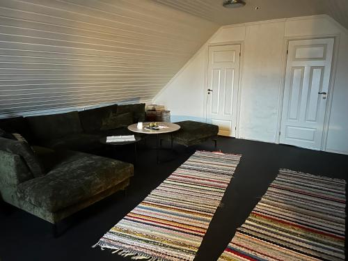 a living room with a couch and a table and two rugs at Svolvær - Jektveien 20 in Svolvær