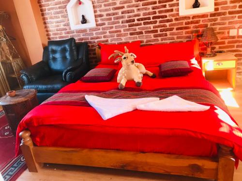 un letto rosso con una capra impagliata seduta sopra di Blue Mountain Home Stay a Kathmandu