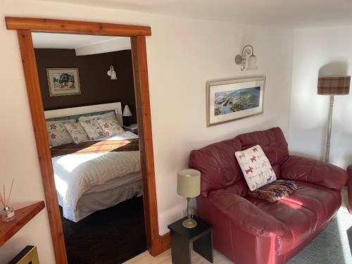 a bedroom with a mirror and a couch and a bed at The Steading at Barmore in Tarbert