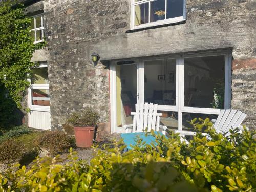 two white chairs in front of a stone house at The Steading at Barmore in Tarbert