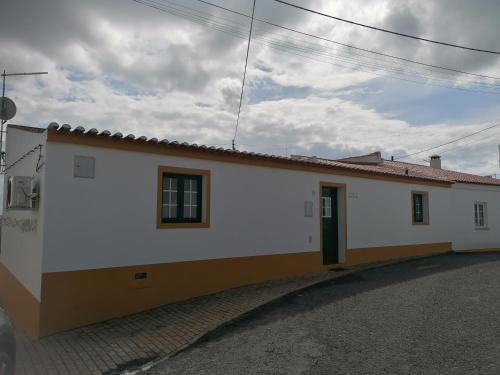 a white building with a door on a street at A Casa da Carolina in Mértola