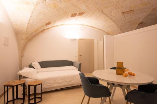 a room with a bed and a table and chairs at Masseria Galleppa by Apulia Hospitality in Monopoli