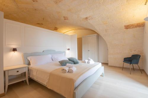 a bedroom with a bed with towels on it at Masseria Galleppa by Apulia Hospitality in Monopoli