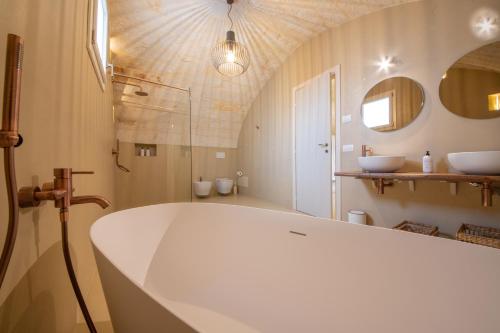 a bathroom with a large tub and a sink at Masseria Galleppa by Apulia Hospitality in Monopoli