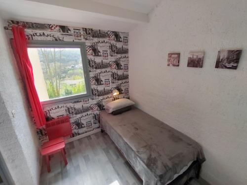 a small bedroom with a bed and a window at Village Bord de Ciel in Caylus