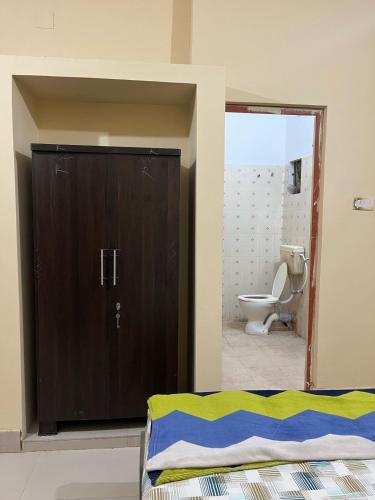 a bathroom with a door open to a toilet at GoodLyfe Homes in Bhubaneshwar