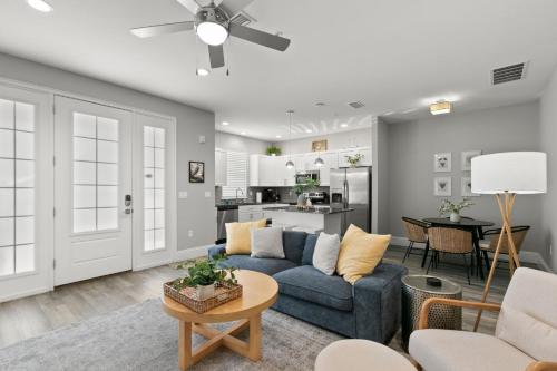 una sala de estar con un sofá y una mesa en Canopy Couplet - 2 Upscale Condos by Main St, en Safety Harbor
