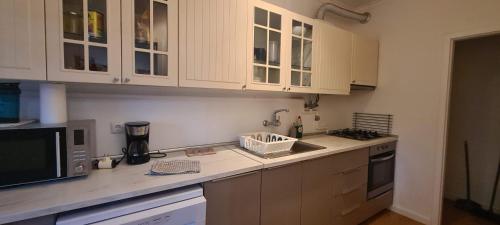 una cucina con mobili bianchi e un piano di lavoro di Joli appartement 2 chambres avec vue sur le Tage à Algés ad Algés