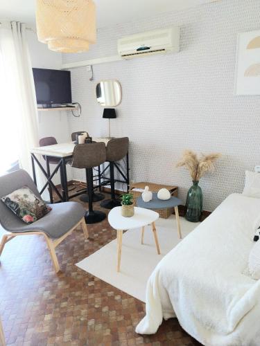 une chambre avec un lit, une table et des chaises dans l'établissement Grazel appartement 4 Couchages et parking privé, à Gruissan