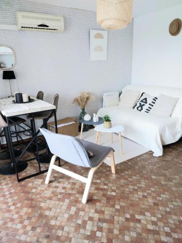 une chambre avec un lit, une table et des chaises dans l'établissement Grazel appartement 4 Couchages et parking privé, à Gruissan