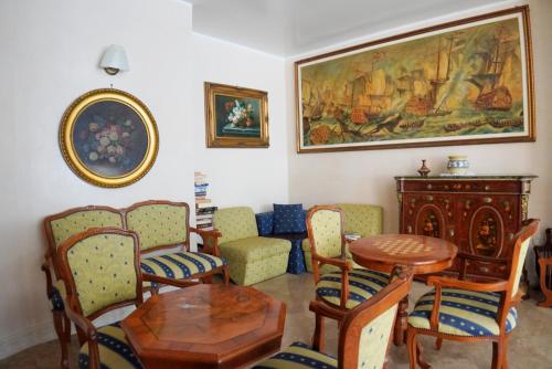 a living room with a table and chairs and a painting at New Hotel Sonia in Santa Maria di Castellabate