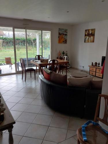 un salon avec un canapé, une table et des chaises dans l'établissement Maison en campagne, à Lahourcade