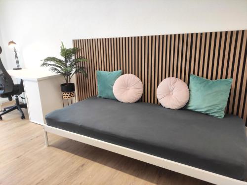 a bed with three pillows on top of it at Top duplex Apartment Zurich-Limmattal in Killwangen