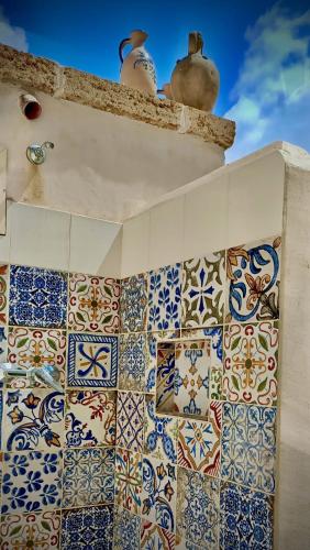 a bathroom with colorful tiles on the wall at Le Mennule 26 in Alliste
