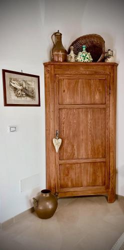 a wooden cabinet in a room with a tea pot at Le Mennule 26 in Alliste