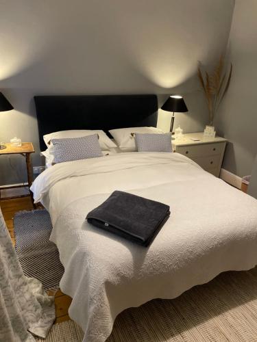 a bedroom with a white bed with a black towel on it at River walk . Shrewsbury.Shropshire.With parking. in Shrewsbury