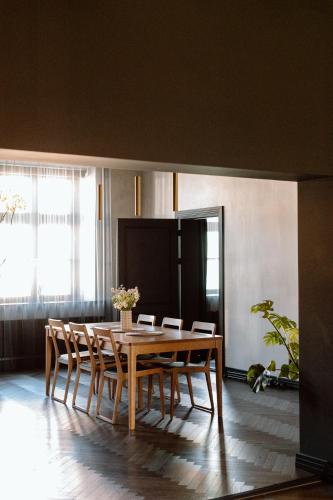 a dining room with a wooden table and chairs at Black Princess in Cēsis
