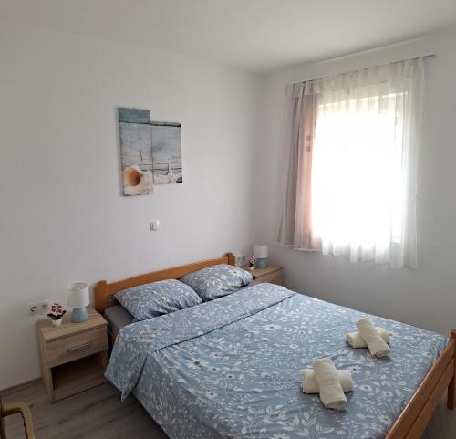 a bedroom with a bed with two towels on it at Apartmani Martinović in Vir