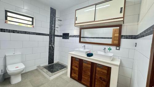 a bathroom with two sinks and a toilet at Villa J&J Private pool near beach in Albion