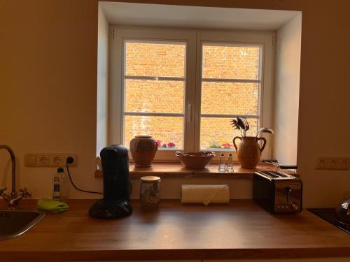 a kitchen with a window with vases on a table at Stadthaus Usedom in Usedom Town