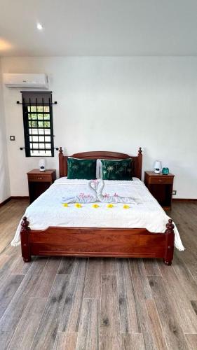 a bedroom with a large bed with a wooden floor at Villa J&J Private pool near beach in Albion