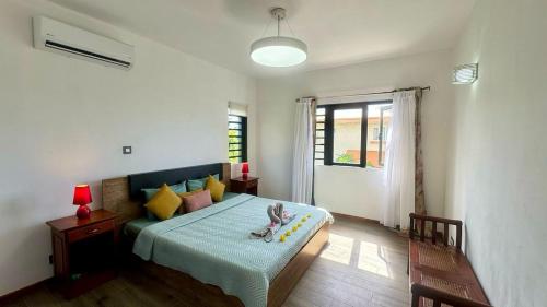 a bedroom with a bed with a child sitting on it at Villa J&J Private pool near beach in Albion