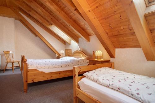 two beds in a room with wooden ceilings at Obst- und Ferienhof Lehle in Immenstaad am Bodensee