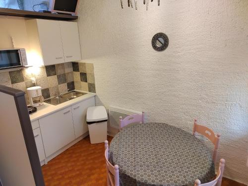 a small kitchen with a table and a sink at Village Bord de Ciel in Caylus